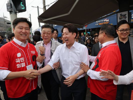 개혁신당 이준석 대선후보가 13일 대구 칠성시장에서 시민들과 인사를 하던 중 국민의힘 김문수 후보 선거운동을 하던 우재준 의원을 만나 악수하고 있다. 연합뉴스