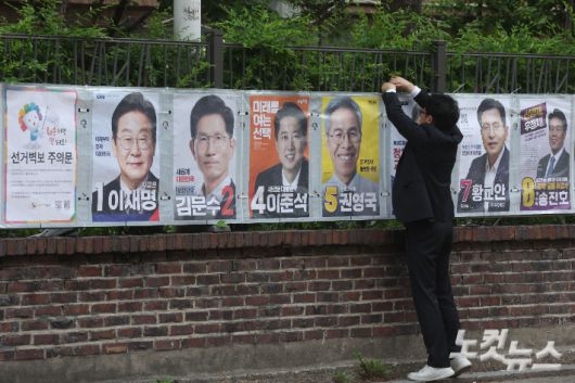 서울시선거관리위원회 관계자들이 15일 오전 서울 종로구 예술가의집 담장에 제21대 대통령선거 선거벽보를 부착하고 있다. 선거벽보는 이날부터 전국 8만2900여 곳에 첩부된다. 류영주 기자