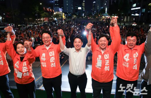 개혁신당 이준석 대선 후보가 12일 오후 서울 중구 청계광장에서 열린 출정식에서 선대위원장들과 두 팔을 들어올리며 시민들에게 인사하고 있다. 윤창원 기자