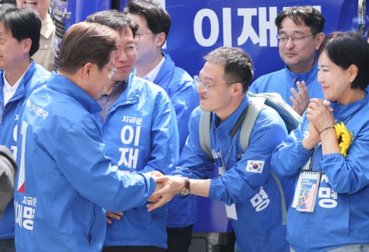 이재명 더불어민주당 대선 후보가 19일 서울 용산역 광장에서 열린 집중유세에 참석하며 이날 민주당에 입당한 김상욱 의원과 인사하고 있다. 류영주 기자