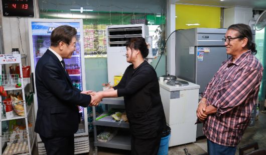 이재명 대통령이 13일 기본소득 실시지역 현황점검을 위해 방문한 경기도 연천군의 한 식당에서 주인과 인사하고 있다. 연합뉴스