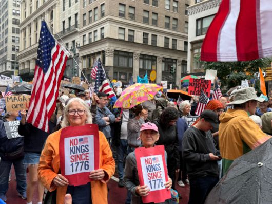 14일(현지시간) 미국 뉴욕 맨해튼 거리에서 열린 '노 킹스' 집회에서 참가자들이 피켓을 들고 행진하고 있다. 연합뉴스
