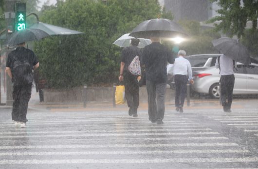 서울 서남권에 호우주의보가 발효된 8일 서울 영등포구 여의도 국회 인근에서 시민들이 우산을 쓰고횡단보도를 건너고 있다. 연합뉴스
