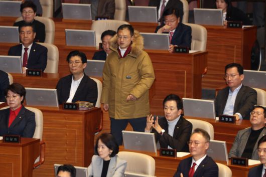 국민의힘 의원들이 지난해 12월 14일 윤석열 대통령 탄핵 소추안 표결이 열리는 국회 본회의장에서 입장하는 김상욱 의원을 바라보고 있다. 연합뉴스