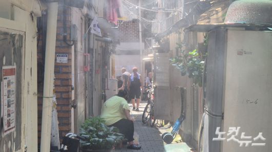 9일 전국 대부분 지역에 폭염특보가 내려진 가운데 서울 종로구 돈의동 쪽방촌 주민들이 골목에서 쿨링포그를 맞으며 더위를 식히고 있다. 송선교 기자