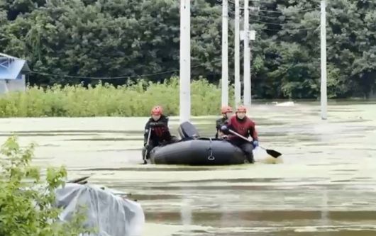 17일 낮 12시 23분쯤 충남 공주시 사곡면의 둑이 무너졌다. 축사로 물이 들어와 고립되자 소방당국이 보트를 이용해 구조하고 있는 모습. 충남소방본부 제공 영상 캡처