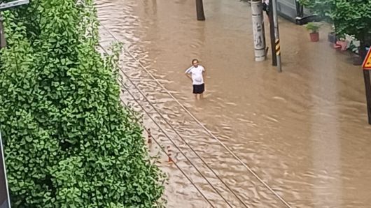 17일 오후 광주 북구 중흥동의 한 도로가 물에 잠겨 도로 유도선이 보이지 않자 인근 시민이 차량통제를 하고 있다. 독자 제공
