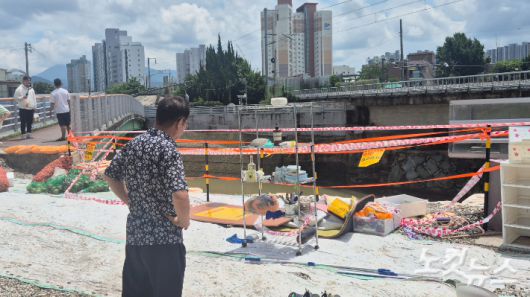 며칠 간 이어진 극한 호우로 광주 북구 신안동의 땅이 꺼지고 옹벽이 부서졌다. 사진 속 주민이 서 있는 곳은 지난 호우로 땅이 꺼졌다가 최근 자갈로 임시 복구를 해뒀다. 한아름 기자