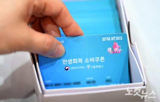 민생회복 소비쿠폰 신청이 시작된 21일 서울 동작구 대방동주민센터 작은도서관에서 시민들이 신청한 선불카드를 받고 있다. 황진환 기자