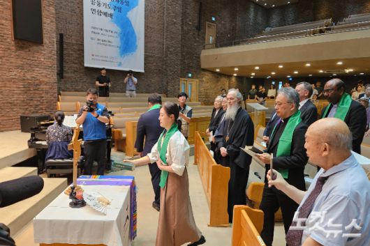 에큐메니칼 공동체 구성원들이 화해와 통일의 상징물을 들고 입장하고 있다. 개신교와 가톨릭 공동으로 번역한 남측 성경, 북측교회가 실제로 사용하는 북측 성경, 각기 다른 나무들로 만들어진 '한 몸 십자가', 물과 흙이 원래 하나이듯 분단의 아픔이 치유되길 바라는 '물과 흙'이 놓여졌다.