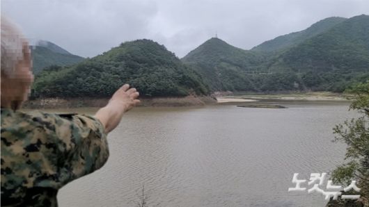 오봉저수지 안에 섬으로 불리는 말구리재를 가리키고 잇는 한 시민. 전영래 기자