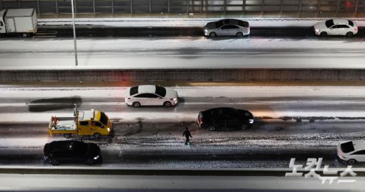 4일 서울 서대문구 홍제동에서 바라본 내부순환로에 시설관리공단 직원이 제설 작업을 하고 있다. 류영주 기자