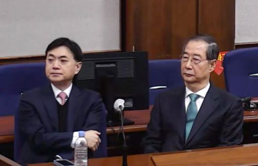 내란 중요임무 종사 혐의를 받는 한덕수 전 국무총리(왼쪽)가 21일 서울중앙지법에서 열린 1심 선고 공판에 출석해 있다. 서울중앙지법 제공