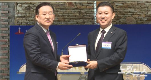 청주시기독교연합회 직전 대표회장인 서원경교회 황순환 목사(오른쪽)가 신임 대표회장인 청주서문교회 박명룡 목사에게 취임패를 전달하고 있다. 충북CBS