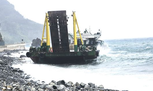 지난 24일 오후 2시30분쯤 울릉공항 공사 현장 앞바다에 정박 중인 바지선이 좌초돼 예인선이 선박을 예인하고 있다.