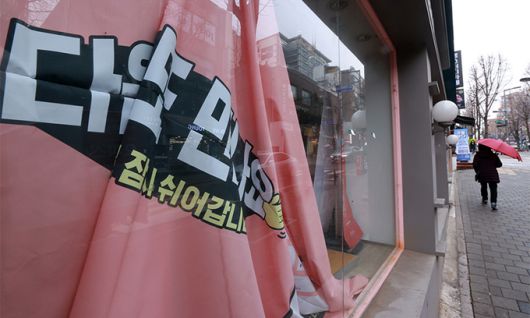 지난 26일 서울 서대문구 대현동 이화여대 인근 거리의 한 폐업 상점 유리에 '다음에 또 만나요, 잠시 쉬어갑니다'란 문구의 현수막이 떨어져 있다. 연합뉴스