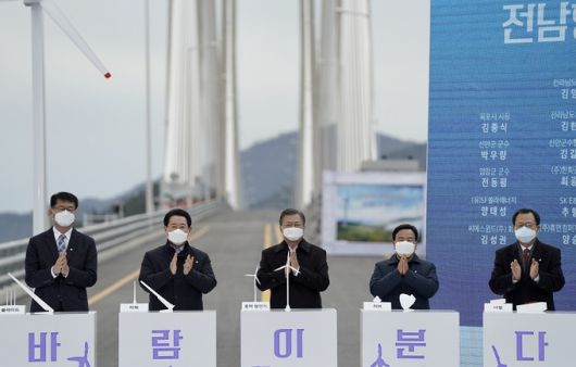 문재인 대통령(사진 가운데)이 5일 오후 전남 신안군 임자2대교에서 열린 ‘세계 최대 해상풍력단지 48조 투자협약식’에서 박수치고 있다. 신안=연합뉴스