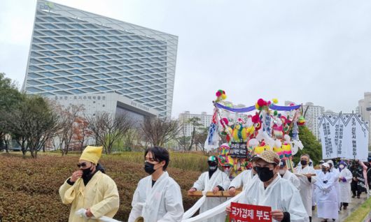 자유연대 회원들이 지난 20일 경남 진주 한국토지주택공사(LH) 본사 앞에서 LH 투기 의혹을 비판하며 상여 행진 퍼포먼스를 벌이고 있다. 진주=연합뉴스