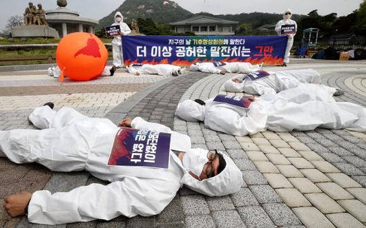 지구의날인 22일 오전 기후위기비상행동이 청와대 분수대 앞에서 뜨거워진 지구에 고통받는 인간을 표현한 퍼포먼스를 하고 있다. 연합뉴스