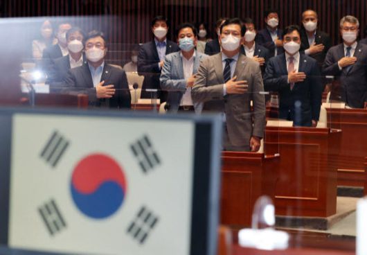 송영길 더불어민주당 대표와 윤호중 원내대표, 의원들이 7일 서울 여의도 국회 예결위회의장에서 열린 정책의원총회에서 국기에 경례하고 있다. 공동취재사진