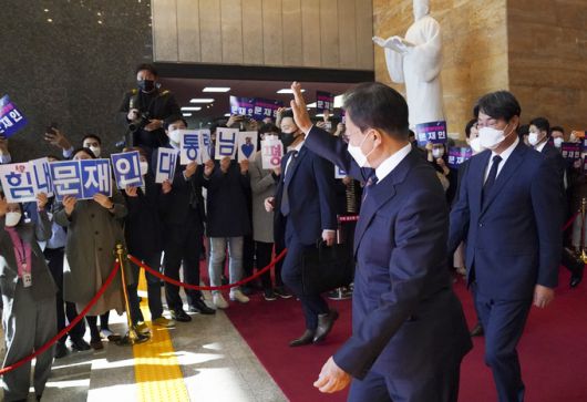 문재인 대통령이 25일 2022년도 예산안 시정연설을 마치고 국회 본청을 나서며 응원하는 당직자들을 향해 손인사를 하고 있다. 뉴스1