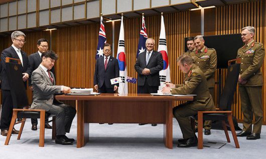 호주를 국빈방문 중인 문재인 대통령이 13일(현지시간) 캔버라 국회의사당에서 스콧 모리슨 호주 총리와 함께 한화디펜스와 호주 국방부획득관리단의 호주 육군 K-9 자주포 획득사업 계약 서명을 지켜보고 있다. 캔버라=AP연합뉴스