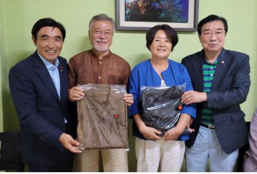 문재인 전 대통령 내외(가운데)가 지난 5일 제주 서귀포시 표선면 한 식당에서 제주4·3희생자유족회 오임종 회장(맨 왼쪽)과 양조훈 고문에게 천연 염색된 옷을 선물 받고 기념 촬영을 하고 있다. 제주4·3희생자유족회 제공