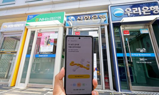 금융권의 온라인·원스톱 대환대출 플랫폼이 시행된 지난 5월 31일 서울 시내에 설치된 시중은행들의 ATM기와 카카오페이 대출 비교 서비스 '대출 갈아타기' 화면 모습. 연합뉴스
