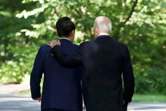 윤석열 대통령이 18일(현지시간) 메릴랜드주에 있는 미국 대통령 별장 캠프 데이비드에서 열린 한미일 공동기자회견을 마친 뒤 조 바이든 미국 대통령과 이동하고 있다. 뉴시스