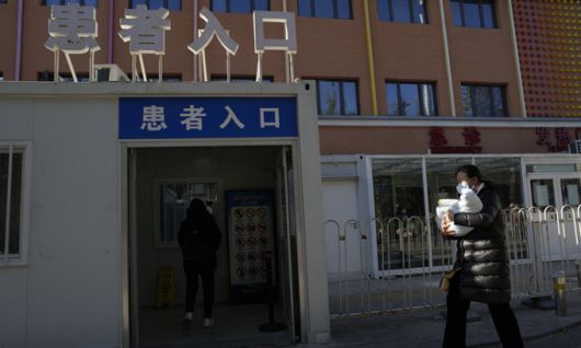 지난 11월 24일 중국 베이징의 한 어린이 병원에 아기 환자를 안은 보호자가 들어가고 있다. AP연합뉴스