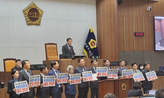 충남학생인권조례 폐지안 처리가 예정된 15일 충남도의회 제348회 정례회 제4차 본회의에 앞서 더불어민주당 도의원들이 '역사 앞에 부끄러울 학생인권조례 폐지 반대'라는 손팻말을 들고 서 있다. 연합뉴스