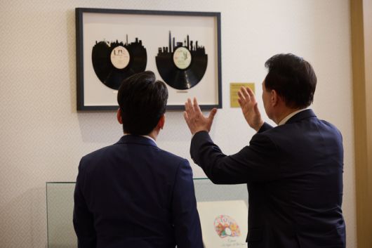 윤석열 대통령이 지난 4일 서울 용산 대통령실 청사에서 가진 KBS '특별대담 대통령실을 가다' 녹화를 마친 뒤 박장범 KBS 앵커에게 지난해 4월 미국 국빈 만찬 시 토니 블링컨 미 국무장관이 증정한 레코드판을 소개하고 있다. 연합뉴스