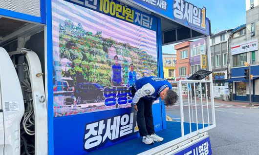 더불어민주당 장세일 전남 영광군수 후보가 8일 영광스포티움 앞 유세차량 위에서 허리를 90도로 숙여 지나가는 차량과 지역 주민에 아침인사를 건네고 있다.