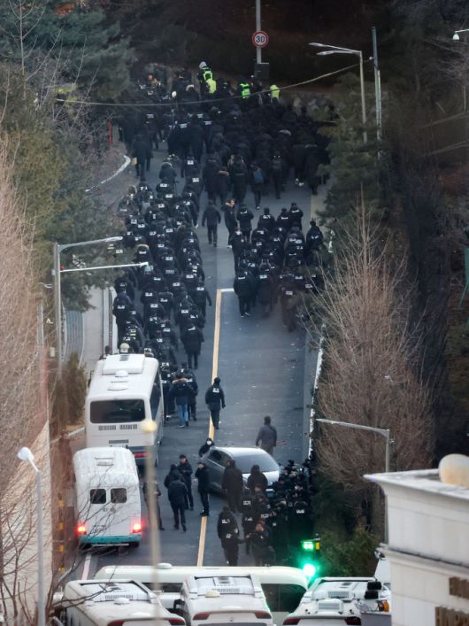 고위공직자범죄수사처와 경찰로 구성된 공조수사본부가 윤석열 대통령에 대한 2차 체포영장 집행에 돌입한 15일 오전 공수처 수사관들과 경찰 인력이 서울 용산구 한남동 대통령 관저 정문을 통과해 이동하고 있다.   뉴스1