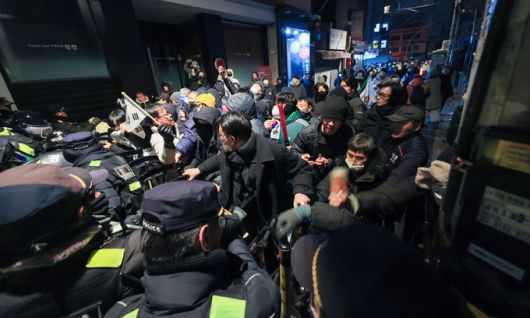 윤석열 대통령이 내란 우두머리 혐의로 구속되자 일부 지지자들이 서울 마포구 서울서부지방법원에 난입한 19일 서부지법 후문 인근에서 경찰이 시위 중인 윤 대통령 지지자들을 해산시키려고 하자 지지자들이 이를 막고 있다. 연합뉴스