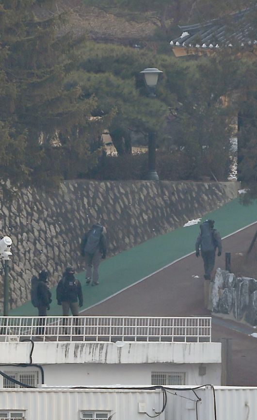 윤석열 대통령 2차 체포영장이 집행되기 이틀 전인 지난 1월13일 서울 용산구 한남동 대통령 관저에서 화기가 든 것으로 추정되는 배낭을 멘 대통령경호처 요원들이 관저 주변을 지키는 모습. 뉴스1