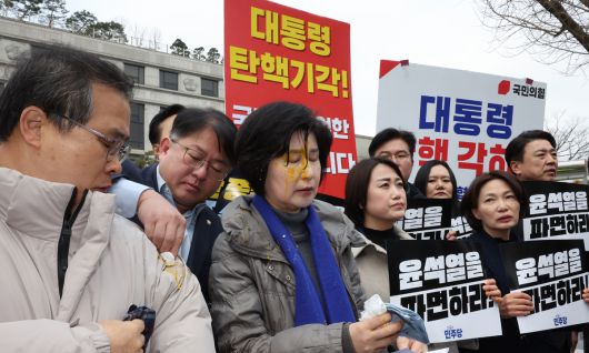 더불어민주당 백혜련 의원이 20일 서울 종로구 헌법재판소 앞에서 열린 민주당 원내부대표단의 윤석열 대통령 신속 파면 촉구 기자회견 도중 얼굴에 계란을 맞아 닦아내고 있다. 연합뉴스