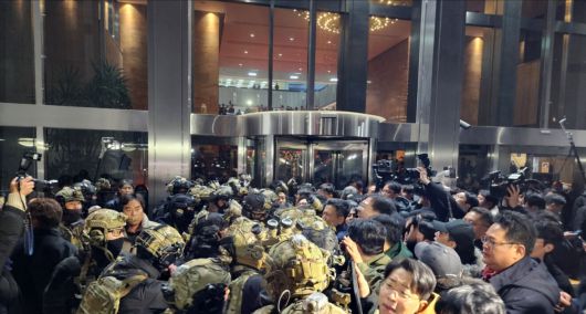 윤석열 대통령이 전격적으로 계엄령을 선포한 직후인 지난해 12월 4일 자정 계엄군 병력이 국회 본청에 진입을 시도하자 국회 보좌진과 의원들이 막아서고 있다. 뉴스1