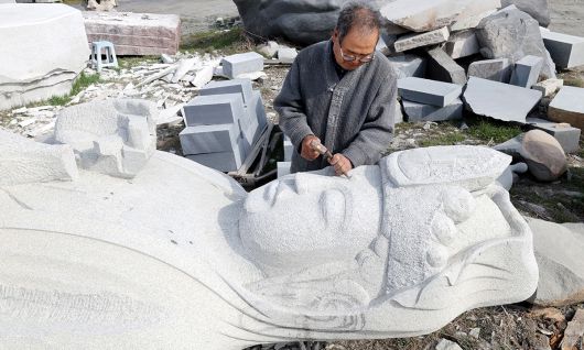 고석산 석장이 망치와 세밀한 조각정으로 해수관세음보살 조성에 집중하고 있다.