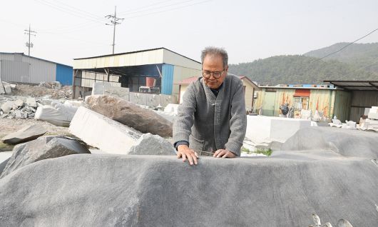 고석산 석장이 작업장에서 석불 작업에 사용할 재료를 선택하고 있다.
