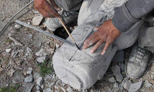 축소 재현 조성 중인 미륵불 부처에 고석산 석장이 자로 크기를 표시하고 있다.