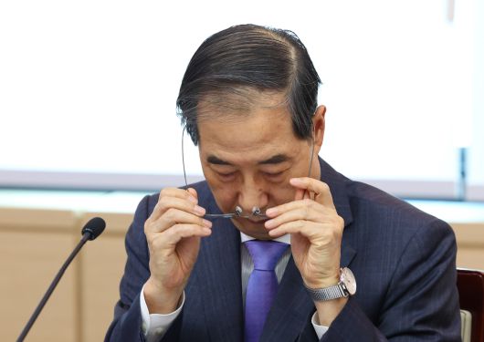 한덕수 대통령 권한대행 국무총리가 17일 정부서울청사에서 열린 제6차 2025년 아시아태평양경제협력체(APEC) 정상회의 준비위원회에서 안경을 벗고 있다.   뉴시스