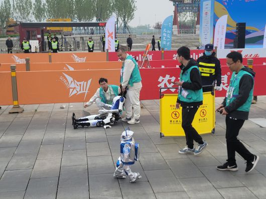 휴머노이드 로봇 ‘환환’이 19일 중국 베이징에서 열린 세계 첫 휴머노이드 마라톤에서 쓰러져 주저앉아 있는 가운데 뒤이어 출발한 ‘샤오쥐런’이 환환을 따라잡고 있다.    베이징=이우중 특파원