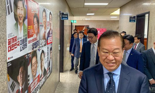 6·3 조기 대선을 43일 앞둔 21일, 국민의힘 권영세 비상대책위원장이 국회 건물 벽에 붙은 당 경선 후보들의 포스터 앞을 지나가고 있다. 국민의힘은 22일 오후 7시 1차 경선 통과자 명단을 발표할 예정이다. 최상수 기자