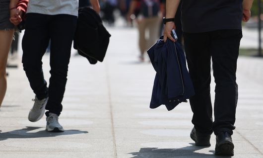 서울 한낮 기온이 26도까지 치솟으며 초여름 날씨를 보인 지난 21일 서울 종로구 광화문광장에서 시민들이 겉옷을 벗어 손에 들고 이동하고 있다. 연합뉴스