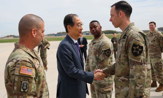 한덕수 대통령 권한대행 국무총리가 23일 경기도 평택시 한미연합사령부를 방문해 산불 진화 작업에 참가했던 윌 마샬 대위와 악수하고 있다. 총리실 제공