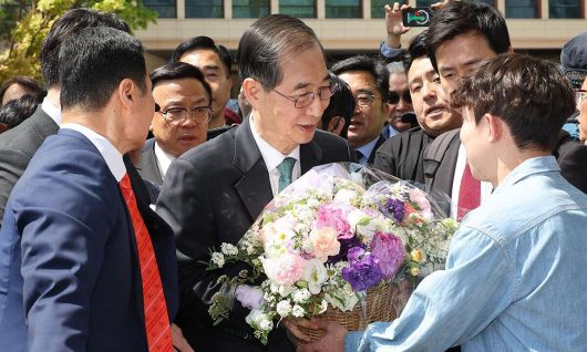 한덕수 전 국무총리가 2일 서울 여의도 국회 소통관에서 대통령 선거 출마 선언을 마치고 나와 지지자로부터 꽃바구니를 받고 있다. 연합뉴스