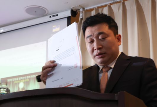 배우 김새론 유족의 법률대리인인 부지석 변호사가 7일 서울 강남구 한 공유오피스에서 기자회견을 열고 김수현에 대한 고소장을 들어 보이고 있다.   연합뉴스