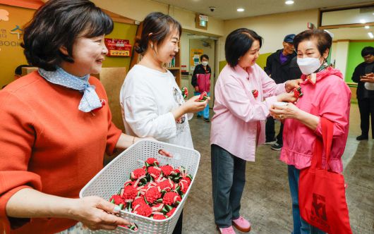 어버이날을 하루 앞둔 7일 서울 동작구 대방종합사회복지관에서 열린 어버이날 행사에서 관계자들이 어르신에게 카네이션을 달아드리고 있다.