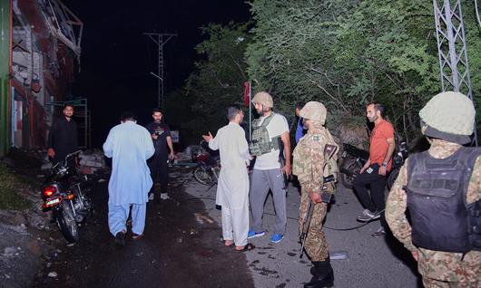 7일(현지 시간) 파키스탄령 카슈미르 무자파라바드 인근에서 취재진과 보안군 관계자들이 인도의 미사일 공격으로 추정되는 피해 현장에 모여 있다.
